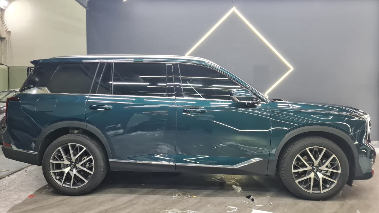 Glossy blue SUV in a workshop with clearly visible body panels