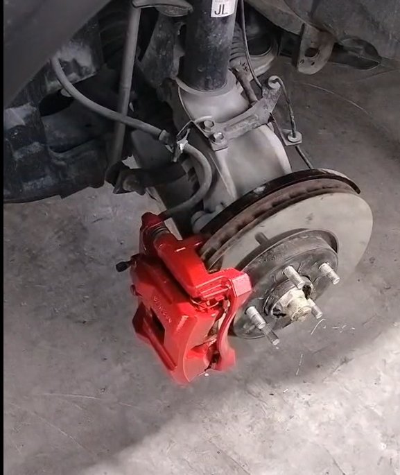Close-up of a red painted brake caliper at Wrapex Car Care